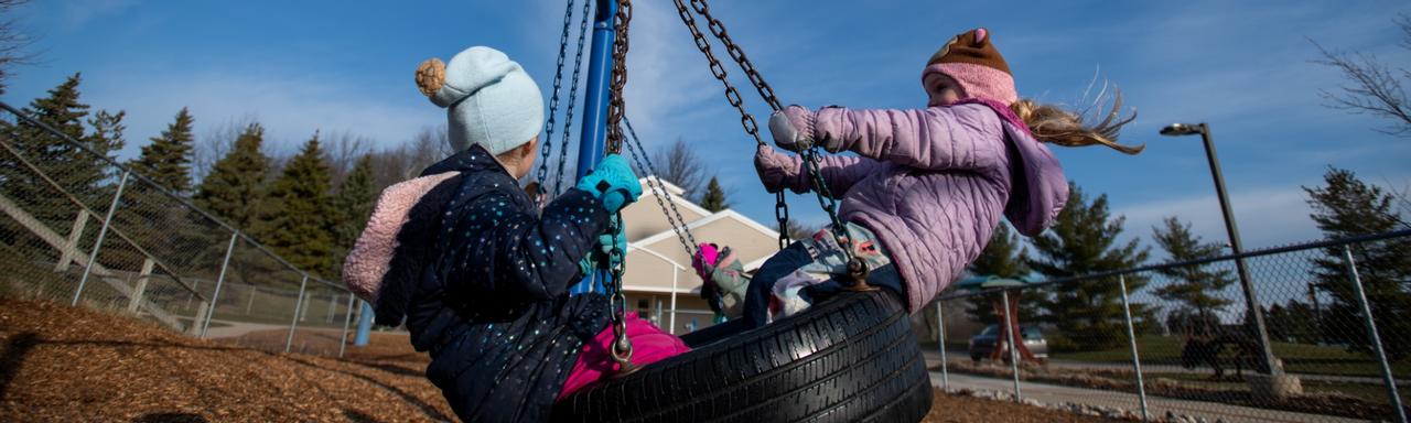 kids swinging on a tire swing